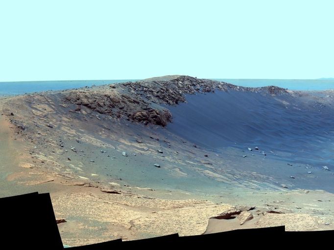 Panorama of 'Santa Maria' Crater for Opportunity's Anniversary (False Color) NASA's Mars Exploration Rover Opportunity is spending the seventh anniversary of its landing on Mars investigating a crater called "Santa Maria," which has a diameter about the length of a football field. This scene looks eastward across the crater. Portions of the rim of a much larger crater, Endurance, appear on the horizon. The panorama spans 125 compass degrees, from north-northwest on the left to south-southwest on the right. It has been assembled from multiple frames taken by the panoramic camera (Pancam) on Opportunity during the 2,453rd and 2,454th Martian days, or sols, of the rover's work on Mars (Dec. 18 and 19, 2010). The view is presented in false color to emphasize differences among materials in the rocks and the soils. It combines images taken through three different Pancam filters admitting light with wavelengths centered at 753 nanometers (near infrared), 535 nanometers (green) and 432 nanometers (violet). Seams have been eliminated from the sky portion of the mosaic to better simulate the vista a person standing on Mars would see. Opportunity landed in the Meridiani Planum region of Mars on Jan. 24, 2004, Universal Time (Jan. 25, Pacific Time) for a mission originally planned to last for three months. Since that prime mission, the rover has continued to work in bonus-time extended missions. Both Opportunity and its twin, Spirit, have made important discoveries about wet environments on ancient Mars that may have been favorable for supporting microbial life. By mid-January 2011, Opportunity reached a location at the southeastern edge of Santa Maria crater. The rover team developed plans for Opportunity to spend a few weeks investigating rocks at that site during solar conjunction, a period when communications between Earth and Mars are curtailed because the sun is almost directly between the two planets. After completion of its work at Santa Maria, the rover will resume a long-term trek toward Endeavour. Image Credit: NASA/JPL-Caltech/Cornell/ASU