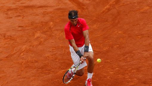 Rafael Nadal odráží míček na Novaka Djokoviče během finále French Open 2012.