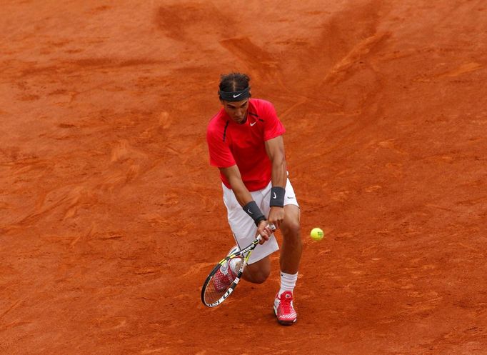 Rafael Nadal odráží míček na Novaka Djokoviče během finále French Open 2012.