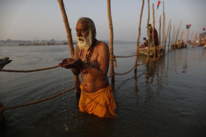 A Hindu devotee prays before taking a dip in the waters of the holy Ganges river ahead of the "Kumbh Mela" (Pitcher Festival) in the northern Indian city of Allahabad January 11, 2013. During the festival, Hindus take part in a religious gathering on the banks of the river Ganges. "Kumbh Mela" will return to Allahabad in 12 years. REUTERS/Ahmad Masood (INDIA - Tags: RELIGION TPX IMAGES OF THE DAY) Published: Led. 11, 2013, 10:24 dop.