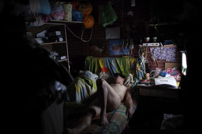 Xiao Cao, a 57-year-old gay man, lays down on his bed in his eight-square-metre apartment in Shanghai April 22, 2012. China's gay community has long been on the edges of society but it is gradually becoming more accepted. Cao, who is an unemployed drag queen, is one whose life lifts the curtain on a less romanticised view of Chinese homosexuals. Living in an eight-square-metre apartment behind a public toilet and with a monthly income of 500 yuan ($79) from social insurance, he passes his days dancing in public and spending time with friends at gay clubs. Picture taken April 22, 2012. REUTERS/Aly Song (CHINA - Tags: SOCIETY) TEMPLATE OUT. CHINA OUT. NO COMMERCIAL OR EDITORIAL SALES IN CHINA. ATTENTION EDITORS PICTURE 28 OF 28 OF PACKAGE 'GAY AND OUT IN CHINA' TO FIND ALL IMAGES SEARCH 'GAY OUT CHINA' Published: Čer. 1, 2012, 12:42 dop.