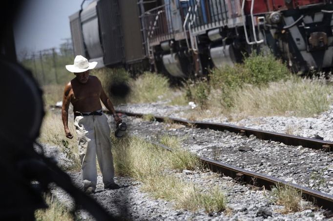 Emiliano walks along the train tracks and outside a train carriage he calls home in Cadereyta on the outskirts of Monterrey August 7, 2012. Emiliano, his eight other family members and their pets have been living in the abandoned carriage next to a train track for the last 15 years. Emiliano and his wife moved from Tamaulipas to Cadereyta after one of their sons was killed on the street by a stray bullet. The family moved into the carriage, which was empty after having been occupied by a vagabond, after living for the first five years in a rented room after arriving in Cadereyta. Picture taken August 7, 2012. REUTERS/Daniel Becerril (MEXICO - Tags: SOCIETY) Published: Srp. 11, 2012, 2:53 dop.