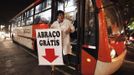 A member of the Traffic Psychologists gets off a bus as he holds a banner that reads "Free Hugs" during his performance in Sao Paulo July 23, 2012. Traffic Psychologists is a non-profit non-governmental organization which aims to humanize traffic and reduce the level of stress caused to drivers. Sao Paulo has more than 7 million vehicles, according to figures from the state transport authority Detran. Picture taken July 23, 2012. REUTERS/Nacho Doce (BRAZIL - Tags: TRANSPORT SOCIETY TPX IMAGES OF THE DAY) Published: Čec. 24, 2012, 7:02 dop.