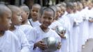 Novice Thai nuns stand in line to receive food at the Sathira Dammasathan Buddhist meditation centre in Bangkok