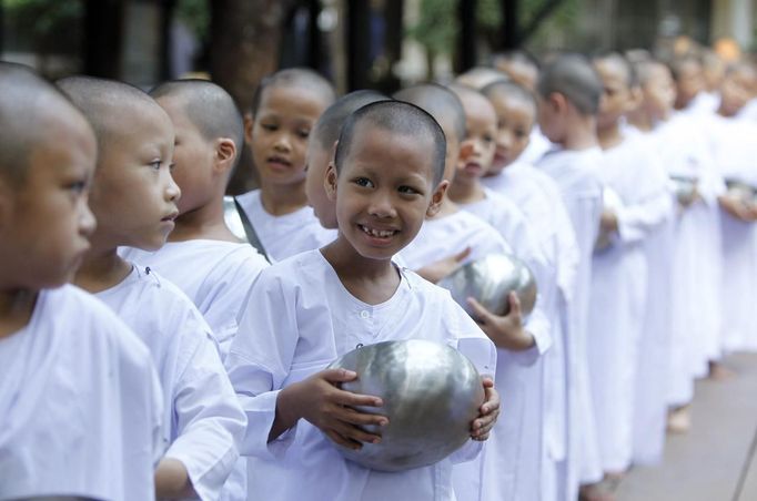 Novice Thai nuns stand in line to receive food at the Sathira Dammasathan Buddhist meditation centre in Bangkok