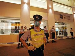 Hongkong. Policistá hlídá před hotelem v karanténě