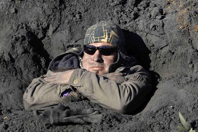 A local resident buries himself into an ash deposit during a protest at Coronel town south of Santiago, June 25, 2012. Locals have been protesting against a thermo-electric plant of Spanish company Endesa that is contaminating their land and waters and covering their town with heavy pollution, according to local media. REUTERS/Jose Luis Saavedra (CHILE - Tags: SOCIETY ENVIRONMENT POLITICS CIVIL UNREST) Published: Čer. 25, 2012, 8:52 odp