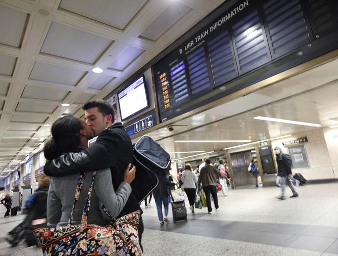 A couple kisses good bye before the last train to Long Island departs Penn Station in New York October 28, 2012. Authorities shut transit systems and ordered some evacuations as tens of millions of people on the East Coast braced for Hurricane Sandy, a gigantic storm forecast to deliver battering winds, dangerous flooding and even heavy snowfall. REUTERS/Brendan McDermid (UNITED STATES - Tags: DISASTER ENVIRONMENT TRANSPORT) Published: Říj. 29, 2012, 12:43 dop.