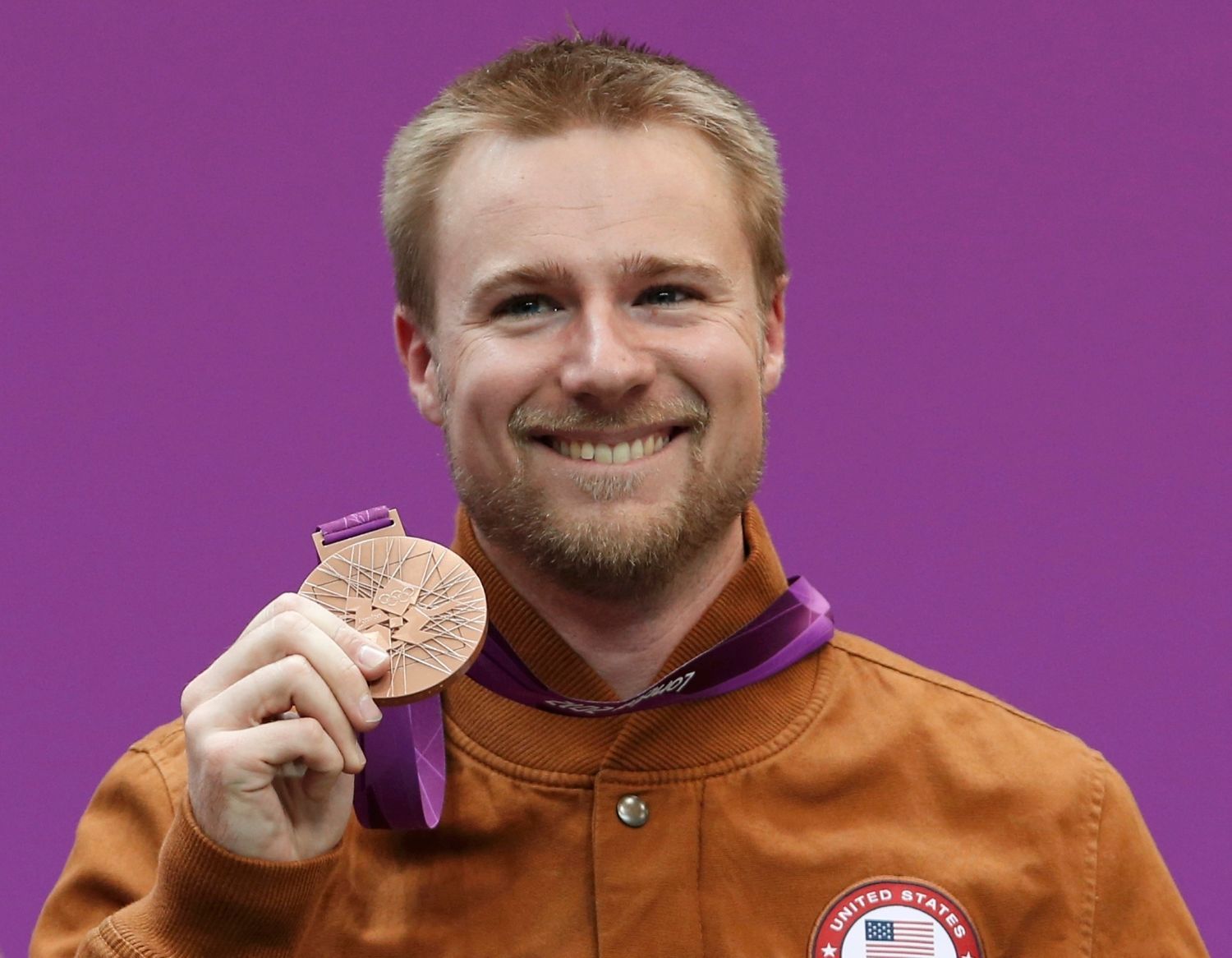 Americký střelec Matthew Emmons se raduje s bronzovou medailí na OH 2012 v Londýně.