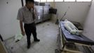 A security guard holds his breath while standing next to the covered-up dead body of a 16-year old boy who had gunshot to his head, at the morgue of a local hospital in San Pedro Sula March 24, 2013. San Pedro Sula, the country's second largest city after Tegucigalpa, has a homicide rate of 169 per 100,000 people and was named the world's most violent city for a second year in a row. Lax laws allow civilians to own up to five personal guns. Arms trafficking has flooded the country with nearly 70% illegal firearms. 83.4% of homicides are by firearms, compared to 60% in the United States. Picture taken March 24, 2013. REUTERS/Jorge Cabrera (HONDURAS - Tags: CRIME LAW CIVIL UNREST HEALTH) ATTENTION EDITORS: PICTURE 36 OF 39 FOR PACKAGE 'GUN CULTURE - HONDURAS' SEARCH 'HONDURAS GUN' FOR ALL IMAGES Published: Dub. 5, 2013, 11:15 dop.