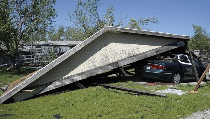 A view of a home and car that were damaged by a tornado in the southern area of Wichita