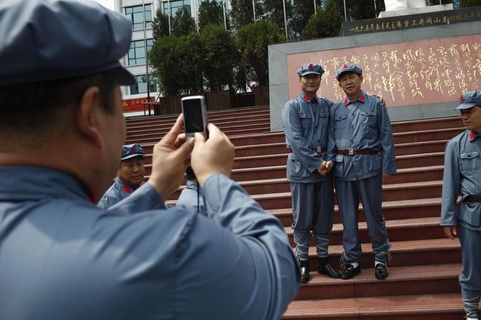 Visitors, dressed as red army soldiers, pose for pictures in Jinggangshan, Jiangxi province September 20, 2012. Jinggangshan, is where former Chinese leader Mao Zedong's career as a revolutionary began to take off. In 1927, Mao and several communist leaders fled with a few thousands to the hills of Jinggangshan, hounded and outnumbered by Nationalist forces. REUTERS/Carlos Barria (CHINA - Tags: POLITICS SOCIETY) Published: Zář. 20, 2012, 5:21 dop.