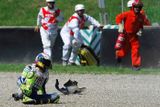 Valentino Rossi se drží po pádu za nohu. Je zle