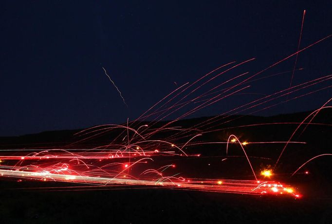 Tracers streaks are illuminated at night during the Big Sandy Shoot in Mohave County, Arizona March 22, 2013. The Big Sandy Shoot is the largest organized machine gun shoot in the United States attended by shooters from around the country. Vintage and replica style machine guns and cannons are some of the weapons displayed during the event. Picture taken March 22, 2013. REUTERS/Joshua Lott (UNITED STATES - Tags: SOCIETY) Published: Bře. 25, 2013, 3:34 odp.