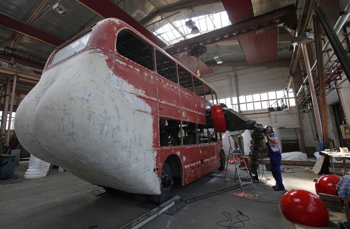 A worker welds as artist David Cerny (not pictured) works on his project to transform a London bus into a robotic sculpture at a factory in Prague May 9, 2012. The bus, which Cerny hopes could become an unofficial mascot of the London 2012 Olympic Games, does push-ups with the help of an engine powering a pair of robotic arms and the motion is accompanied by a recording of sounds evoking tough physical effort. It will be parked outside the Czech Olympic headquarters in London for the duration of the Games. Picture taken May 9, 2012. REUTERS/David W Cerny (CZECH REPUBLIC - Tags: SOCIETY SPORT OLYMPICS TRANSPORT) Published: Čec. 22, 2012, 5:52 odp.