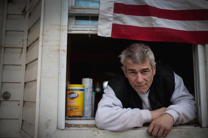 Patrick Zoda, a former New York City Fire Department Fire Fighter, poses for a photograph in the front window of his house in Midland Beach, Staten Island November 15, 2012. Zoda, 46, tried to ride out Hurricane Sandy but as waters quickly rose around his one-story home he was forced to escape by wading through neck-deep water to safety. Zoda who plans to rebuild his home said, "It's just like after 9/11... we support each other and this is my home, I'm not going anywhere." Picture taken November 15, 2012. REUTERS/Mike Segar (UNITED STATES - Tags: DISASTER ENVIRONMENT) ATTENTION EDITORS PICTURE 03 OF 19 FOR PACKAGE 'SURVIVING SANDY' SEARCH 'SEGAR SANDY' FOR ALL PICTURES Published: Lis. 20, 2012, 3:30 odp.