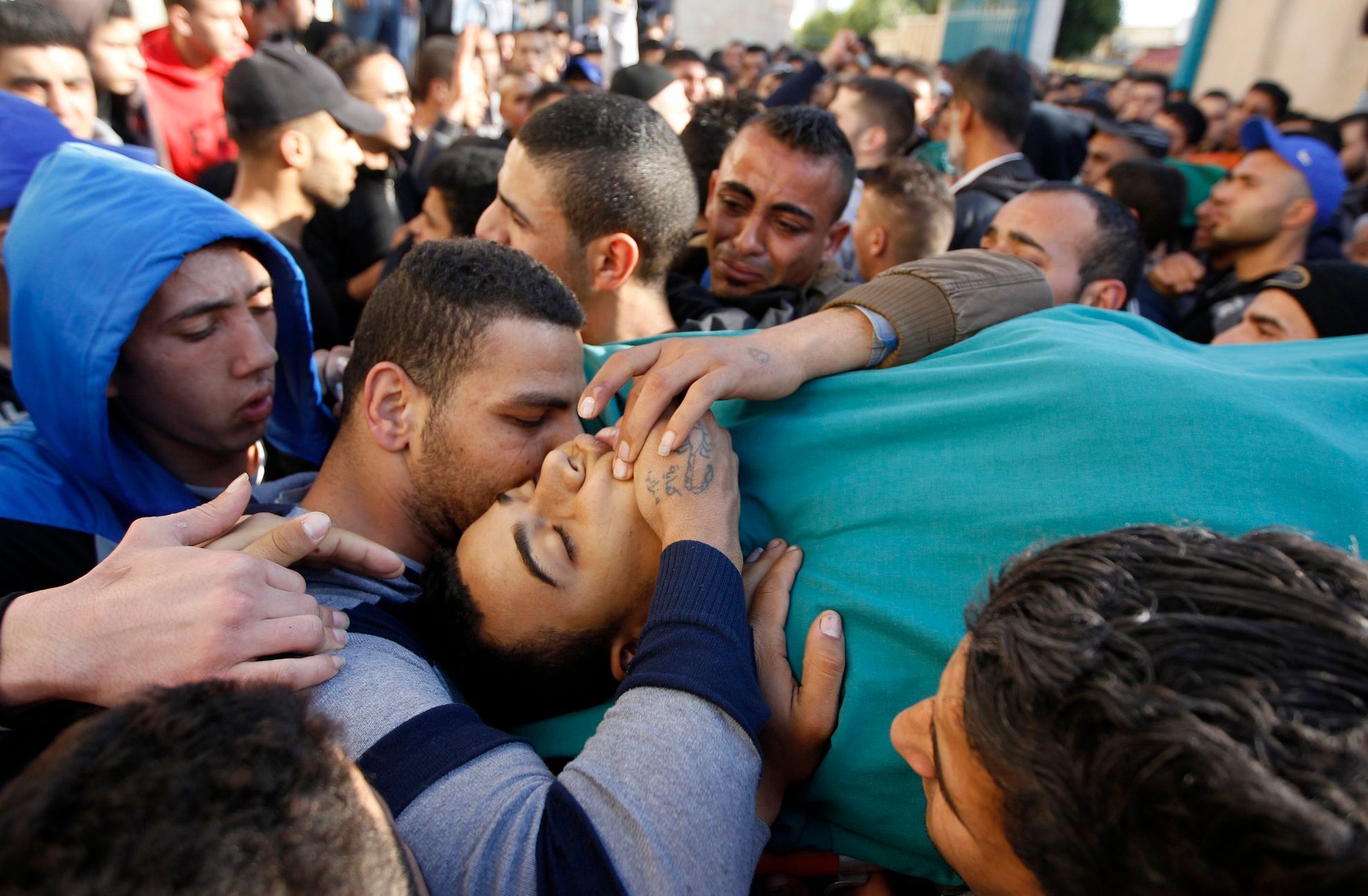 Palestinians shout slogans as they carry the body of militant Hamza Abu Alhija, in the West Bank refugee camp of Jenin
