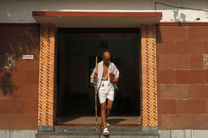 Mahesh Chaturvedi, 63, who dresses up like Mahatma Gandhi, walks out of his residence in the outskirts of New Delhi October 23, 2012. Chaturvedi says that the soul of Gandhi resides in him and he has been sent to continue the work of Father of the Nation. After his self proclaimed transformation in 2002 as Gandhi, Chaturvedi has been travelling extensively and plays up to his startling resemblance to Gandhi at protests and demonstrations. Picture taken October 23, 2012. REUTERS/Mansi Thapliyal (INDIA - Tags: SOCIETY) Published: Lis. 26, 2012, 3:58 dop.