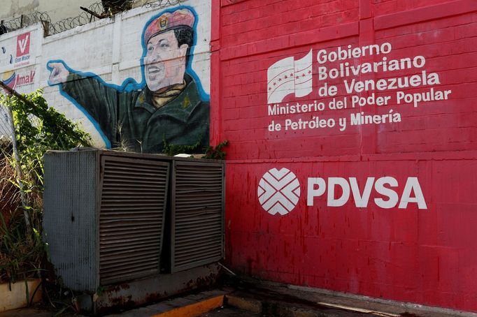 Logo venezuelské státní ropné společnosti a obrázek Hugo Cháveze na čerpací stanici v Caracasu.