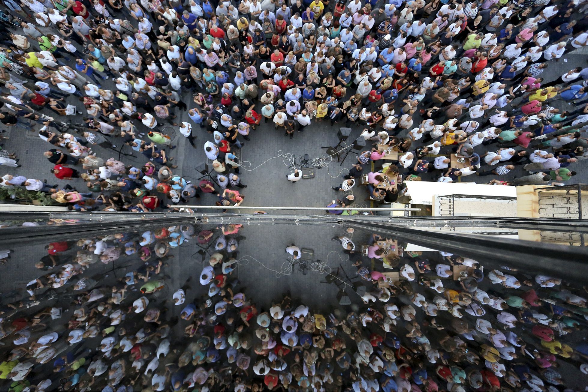 People are reflected on a building as they take part in a pro-EU demonstration in Iraklio on the island of Crete