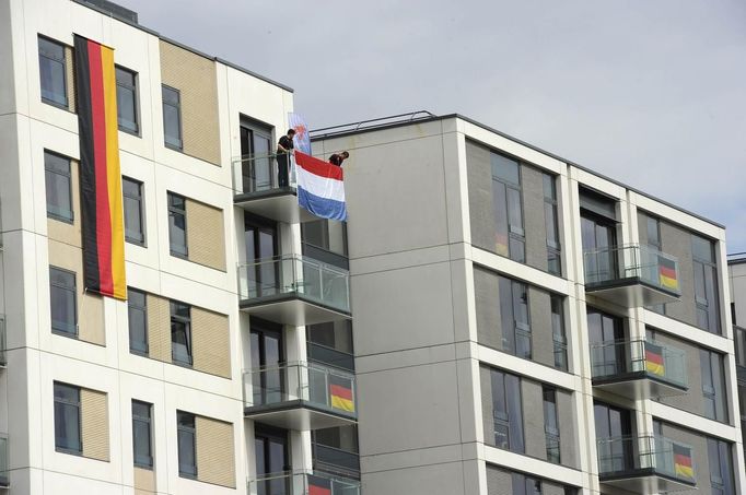 The flag of Luxembourg is draped at a balcony, amidst other flags of Germany, at the athletes village in the Olympic park in Stratford, east London, July 21, 2012. REUTERS/Paul Hackett (BRITAIN - Tags: SPORT OLYMPICS) Published: Čec. 21, 2012, 4 odp.