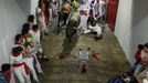 A fallen runner lies in the way of Miura fighting bulls at the entrance to the bullring during the second running of the bulls of the San Fermin festival in Pamplona July 8, 2012. There were no injured runners in the run that lasted two minutes and twenty nine seconds, according to local media. REUTERS/Susana Vera (SPAIN - Tags: ANIMALS SOCIETY) Published: Čec. 8, 2012, 8:29 dop.