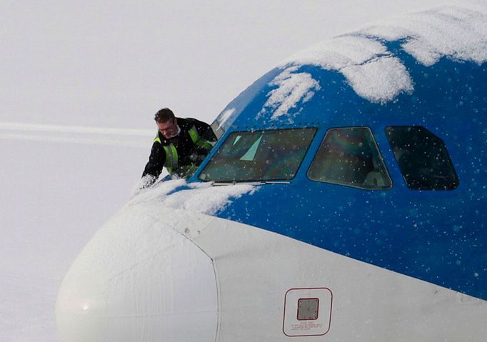 Technik oprašuje stroj na letišti ve skotském Edinburgh. 1. prosince bylo letiště zavřené.