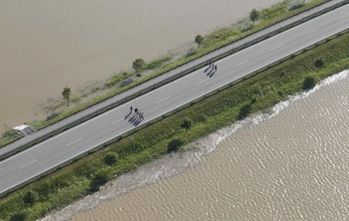 People take a run along a street next to the swollen Elbe river during floods near the village of Fischbeck, in the federal state of Saxony Anhalt, June 10, 2013. REUTERS/Tobias Schwarz (GERMANY - Tags: DISASTER ENVIRONMENT)