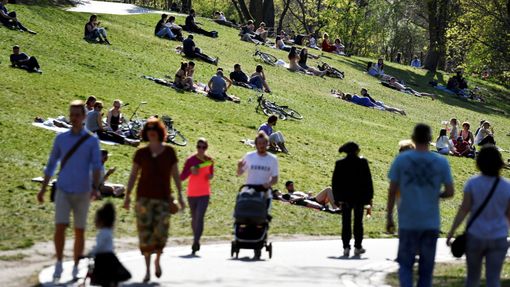Lidé si užívají slunného počasí v berlínském parku.
