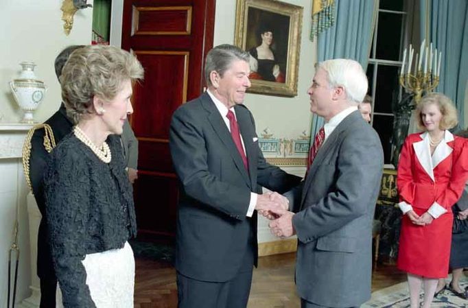 President Ronald Reagan and Mrs. Nancy Reagan greet John McCain in the White House Blue Room during a dinner for newly elected members of the 100th Congress. 1987.