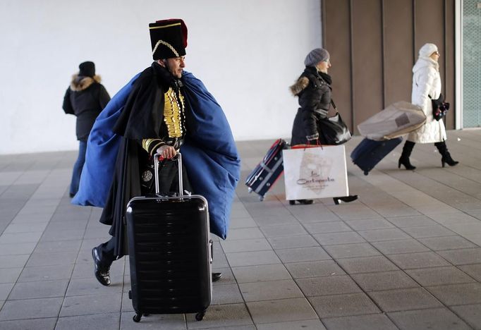 Marco Dilauro arrives to take a vaporetto, or waterbus, at Venice's Canal Grande, with a bag containing costumes which he made for the Venice Carnival January 25, 2013. Dilauro, 43, is a tax collector by day, but his real passion is making masks and costumes for the carnival. A resident of Como, northern Italy, he chooses fabrics, ribbons, lace and costume jewellery to make the period costumes after doing extensive research, and wears them at Carnival, which ends on the day before Ash Wednesday. Picture taken January 25, 2013. REUTERS/Alessandro Bianchi (ITALY - Tags: SOCIETY) Published: Led. 28, 2013, 12:17 dop.