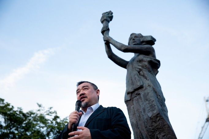 Jeden z vůdců demonstrací na náměstí Nebeského klidu (Tchien-an-men) Wu'er Kchaj-si pod kopií sochy, kterou si demonstranti v roce 1989 vytvořili. Foceno v roce 2022.