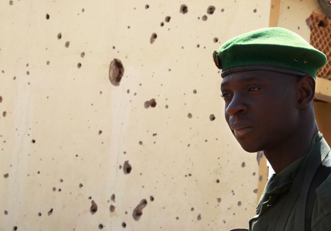 A Malian soldier stands near a wall with bullet holes in the recently liberated town of Konna January 26, 2013. REUTERS/Eric Gaillard (MALI - Tags: CIVIL UNREST CONFLICT MILITARY) Published: Led. 26, 2013, 2:24 odp.