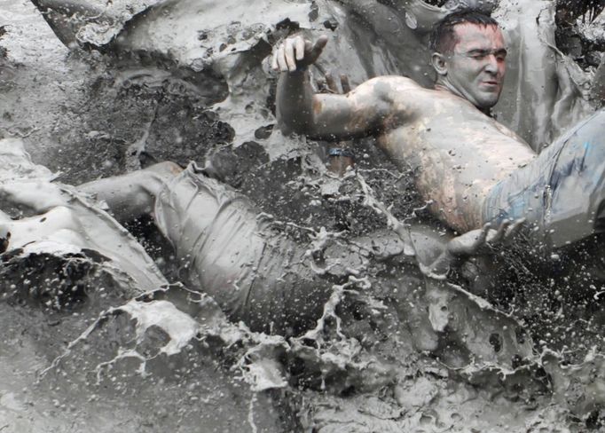 Tourists play in mud during the opening day of the Boryeong Mud Festival at Daecheon beach in Boryeong, about 190 km (118 miles) southwest of Seoul, July 14, 2012. About 2 to 3 million domestic and international tourists visit the beach during the annual festival, according to the festival organisation. REUTERS/Lee Jae-Won (SOUTH KOREA - Tags: SOCIETY TRAVEL) Published: Čec. 14, 2012, 1:24 odp.