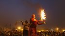 A Hindu priest holds an oil lamp as he performs evening prayers near the banks of river Ganges ahead of the "Kumbh Mela" (Pitcher Festival) in the northern Indian city of Allahabad January 12, 2013. During the festival, Hindus take part in a religious gathering on the banks of the river Ganges. "Kumbh Mela" will return to Allahabad in 12 years. REUTERS/Ahmad Masood (INDIA - Tags: RELIGION SOCIETY) Published: Led. 12, 2013, 3:18 odp.