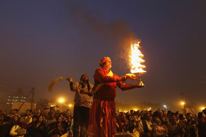 A Hindu priest holds an oil lamp as he performs evening prayers near the banks of river Ganges ahead of the "Kumbh Mela" (Pitcher Festival) in the northern Indian city of Allahabad January 12, 2013. During the festival, Hindus take part in a religious gathering on the banks of the river Ganges. "Kumbh Mela" will return to Allahabad in 12 years. REUTERS/Ahmad Masood (INDIA - Tags: RELIGION SOCIETY) Published: Led. 12, 2013, 3:18 odp.