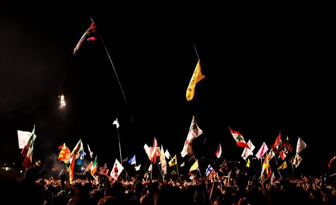 Kanye West is lit up as he hangs over the crowd to perform above the Pyramid stage at Worthy Farm in Somerset during the Glastonbury Festival