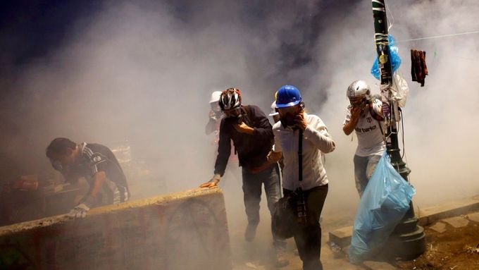 Demonstranti na Taksimském náměstí prchají před slzným plynem, sobota 15. června.