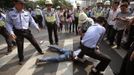 Policemen tackle a demonstrator on the ground during a protest near the Japanese consulate on the 81st anniversary of Japan's invasion of China, in Shanghai September 18, 2012. Anti-Japan protests reignited across China on Tuesday, forcing Japanese firms in the country to suspend operations, as a crisis over a territorial dispute escalated on the day Chinese commemorated Japan's 1931 occupation of its giant neighbour. REUTERS/Aly Song (CHINA - Tags: POLITICS CIVIL UNREST TPX IMAGES OF THE DAY