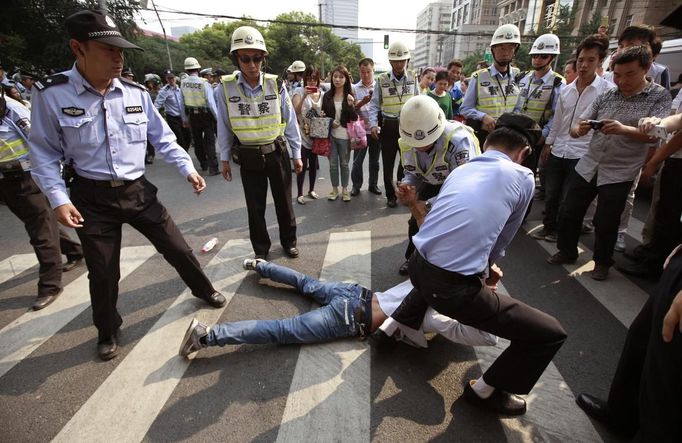 Policemen tackle a demonstrator on the ground during a protest near the Japanese consulate on the 81st anniversary of Japan's invasion of China, in Shanghai September 18, 2012. Anti-Japan protests reignited across China on Tuesday, forcing Japanese firms in the country to suspend operations, as a crisis over a territorial dispute escalated on the day Chinese commemorated Japan's 1931 occupation of its giant neighbour. REUTERS/Aly Song (CHINA - Tags: POLITICS CIVIL UNREST TPX IMAGES OF THE DAY