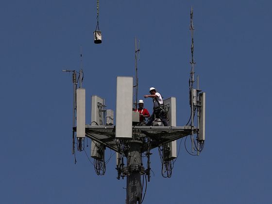 Pracovníci instalují 5G zařízení na telekomunikační věž ve městě Seabrook ve státě Texas.