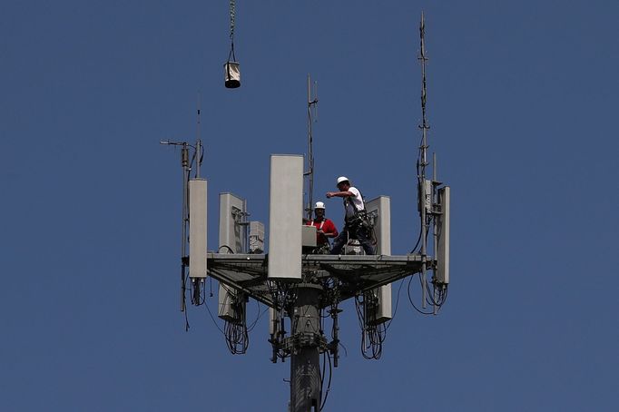 Pracovníci instalují 5G zařízení na telekomunikační věž ve městě Seabrook ve státě Texas.