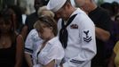 Keith Hoover (R) and Monica Matryba pray while they hold a photo of friend Jon Blunk, killed while protecting his girlfriend in the Century 16 movie theater shootings last Friday, at a prayer vigil for the victims in Aurora, Colorado July 22, 2012. Thousands of Denver-area residents made a sunset pilgrimage to a sprawling park on Sunday to honor the 12 who died and the scores more wounded when a gunman opened fire early Friday in a crowded midnight movie. REUTERS/Rick Wilking (UNITED STATES - Tags: CRIME LAW CIVIL UNREST OBITUARY) Published: Čec. 23, 2012, 4:48 dop.