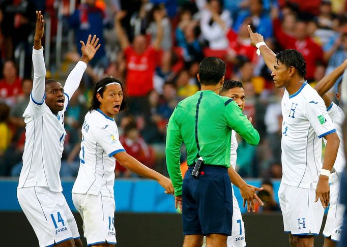 Honduras players argue with referee Sandro Ricci of Brazil after a controversial goal decision during their 2014 World Cup Group E soccer match against France at the Beir