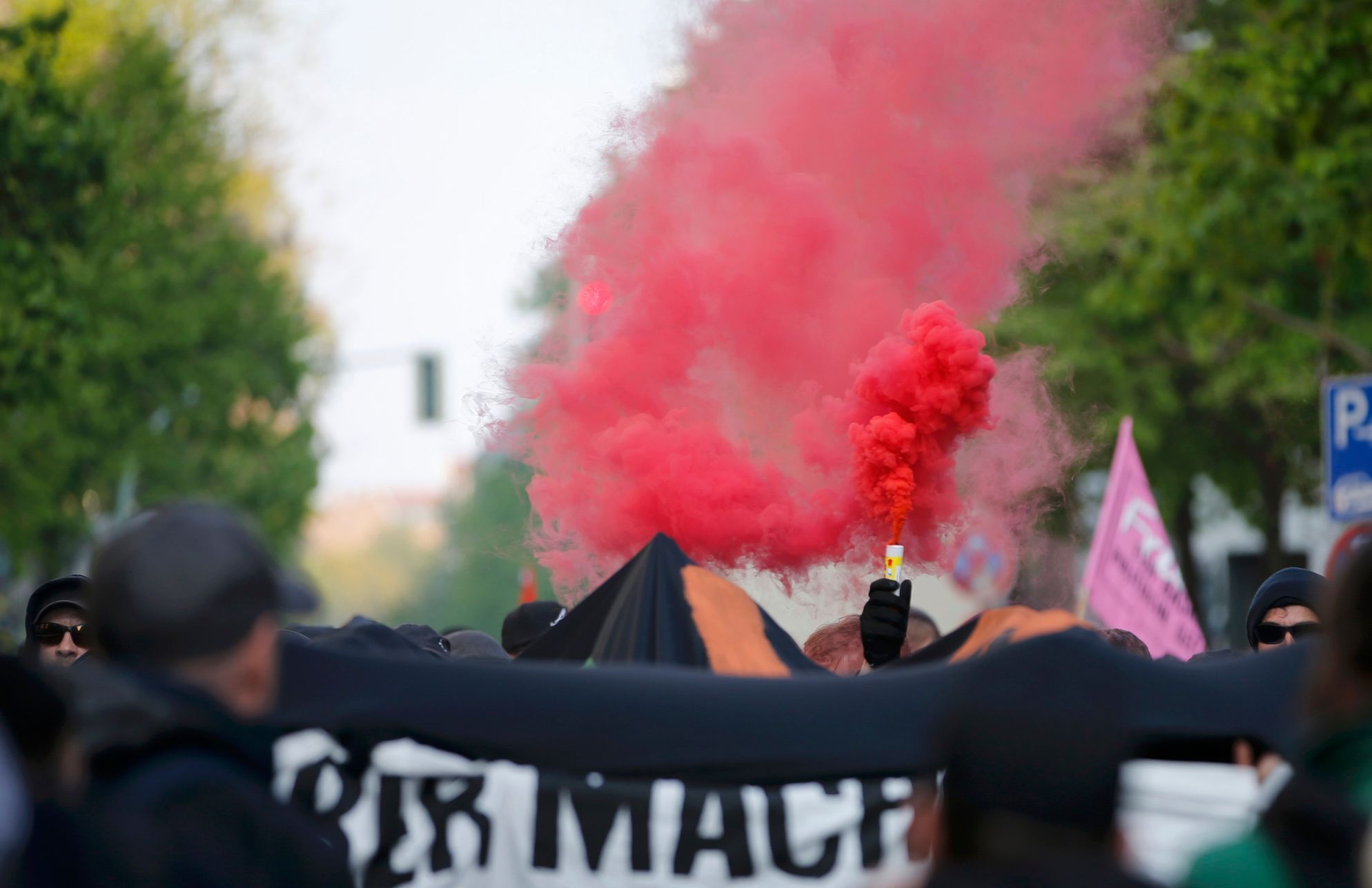 People burn flares as they walk through the streets at the traditional MyFest street festival in Berlin's Kreuzberg district