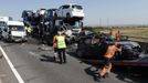 A rescue worker pushes a car on to a recovery truck amongst the wreckage of some of the 100 vehicles involved in multiple collisions, which took place in dense fog during the morning rush hour, on the Sheppey Bridge in Kent, east of London, September 5, 2013. Eight people were seriously injured and dozens hurt in the multiple crashes.