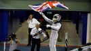 Mercedes Formula One driver Lewis Hamilton of Britain waves the Union flag, commonly known as the Union Jack, in celebration as he enters the pit lane after winning the A