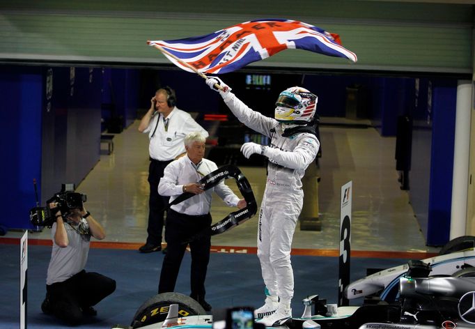 Mercedes Formula One driver Lewis Hamilton of Britain waves the Union flag, commonly known as the Union Jack, in celebration as he enters the pit lane after winning the A