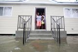 Rodina stojí ve dveřích svého domu v New Orleansu a pozoruje stoupající vodu.
