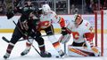 NHL 2019/20, Arizona - Calgary: Christian Dvorak (Arizona) a Travis Hamonic (Calgary) bojují o puk před brankářem Davidem Rittichem